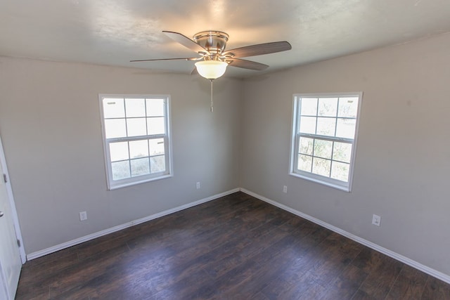 unfurnished room with ceiling fan, a healthy amount of sunlight, and dark wood-type flooring