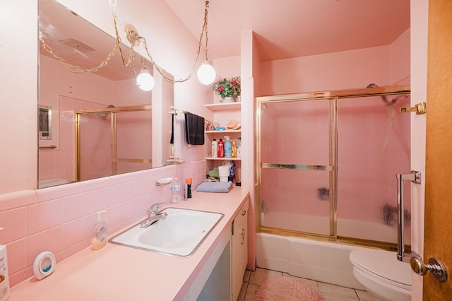 full bathroom with vanity, shower / bath combination with glass door, backsplash, tile patterned flooring, and toilet