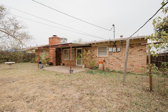 back of property featuring a lawn and a patio