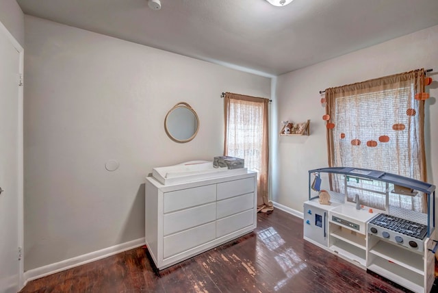 bedroom with dark hardwood / wood-style flooring