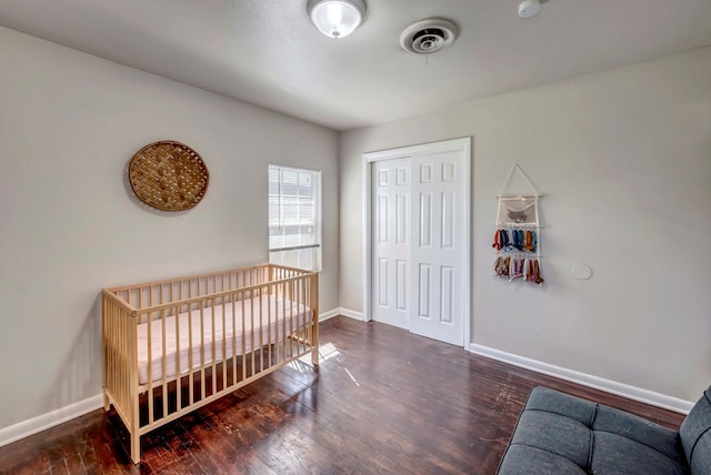 bedroom with dark hardwood / wood-style floors and a closet