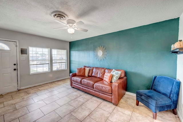 living room featuring light tile patterned floors, a textured ceiling, and ceiling fan