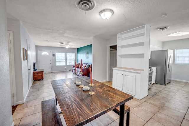 dining area with light tile patterned floors, a textured ceiling, plenty of natural light, and ceiling fan