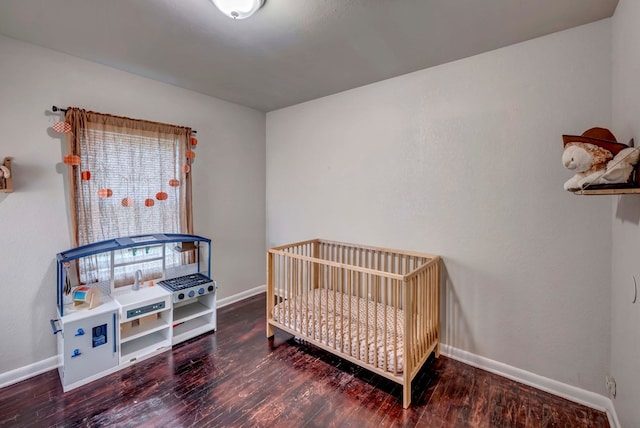 bedroom featuring wood-type flooring and a nursery area