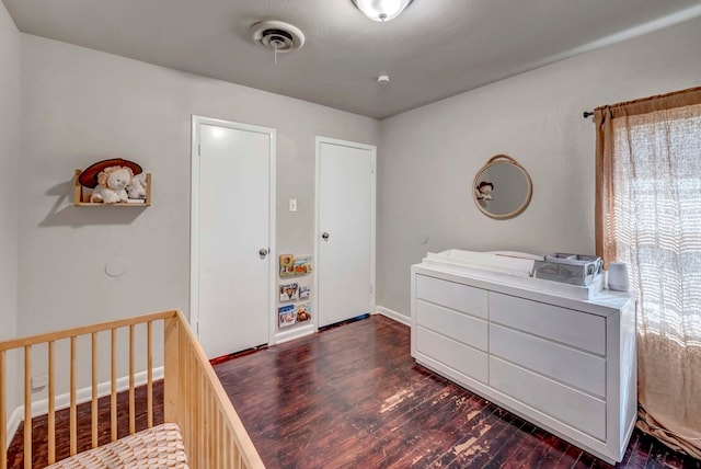 bedroom with dark hardwood / wood-style floors