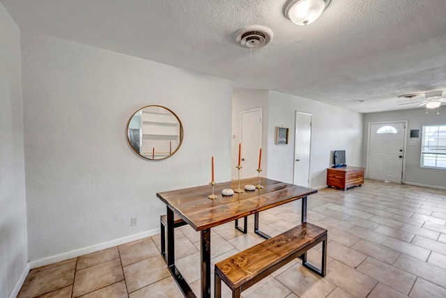 dining room with ceiling fan, a textured ceiling, and light tile patterned floors