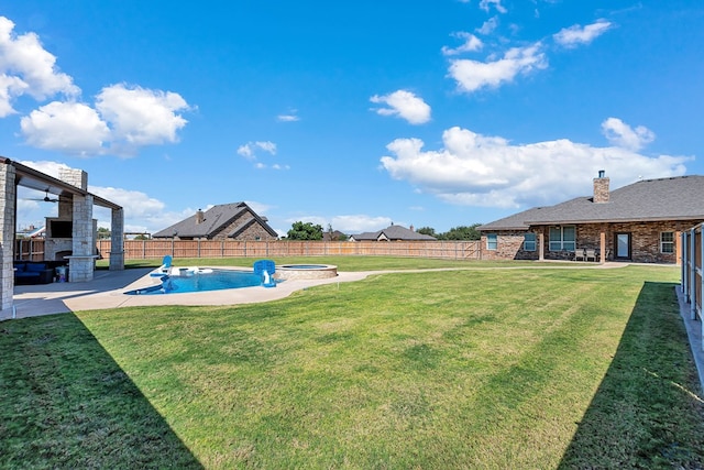 view of yard featuring a swimming pool with hot tub, a fireplace, and a patio