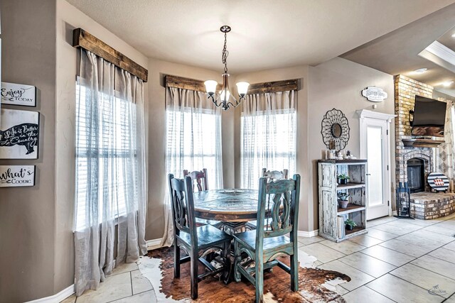 dining area featuring a fireplace, a textured ceiling, a chandelier, and plenty of natural light