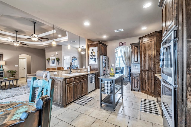 kitchen with dark brown cabinetry, stainless steel appliances, a breakfast bar area, and sink