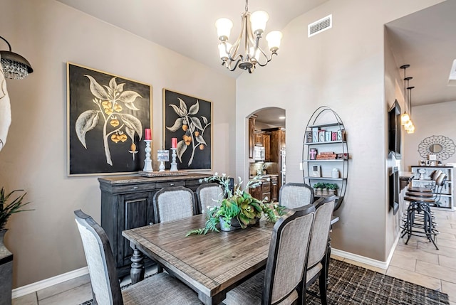 dining space featuring tile patterned flooring and a notable chandelier