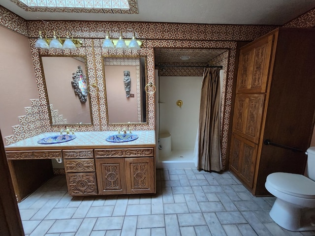 bathroom with toilet, vanity, and walk in shower