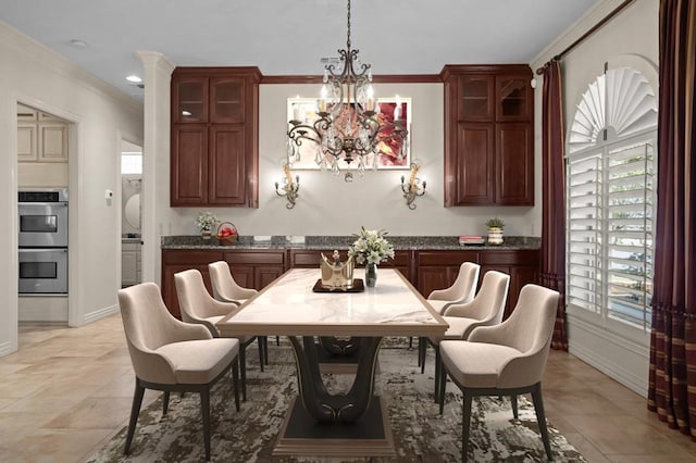 dining room with a chandelier, ornamental molding, and baseboards