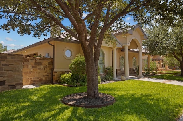 view of front of property featuring a front lawn and stucco siding