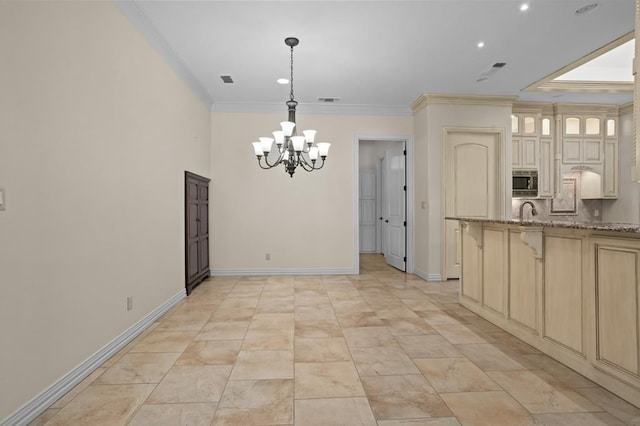 kitchen featuring a notable chandelier, a kitchen breakfast bar, light stone countertops, stainless steel microwave, and crown molding