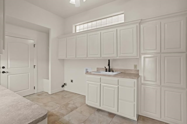 laundry room with washer hookup, a sink, baseboards, cabinet space, and electric dryer hookup