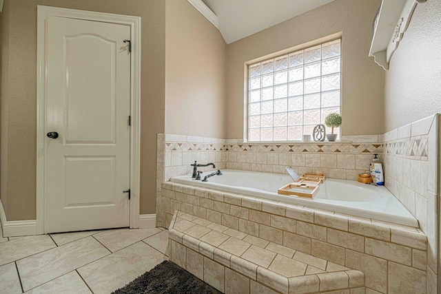 bathroom with tile patterned flooring and tiled tub