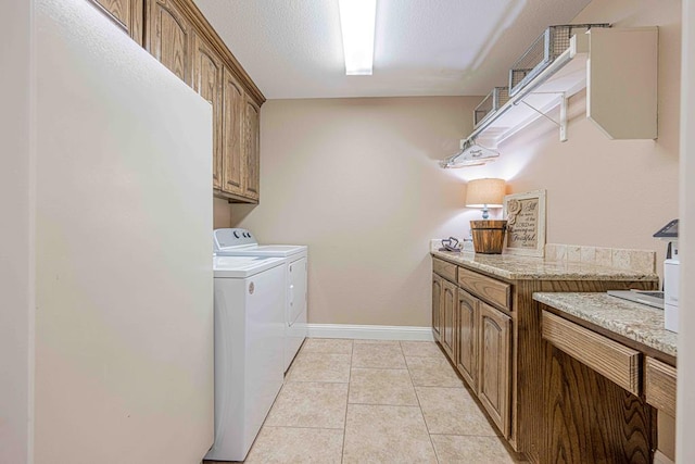 clothes washing area with light tile patterned floors, cabinets, and independent washer and dryer