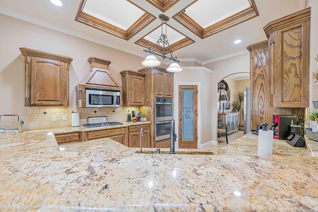 kitchen with sink, coffered ceiling, decorative backsplash, appliances with stainless steel finishes, and ornamental molding