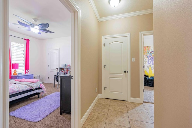 corridor with crown molding and light tile patterned floors