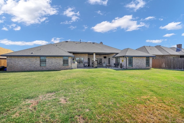 back of property featuring a lawn and a patio