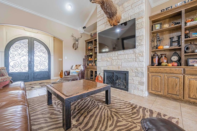 living room with french doors, vaulted ceiling, a fireplace, light tile patterned floors, and ornamental molding