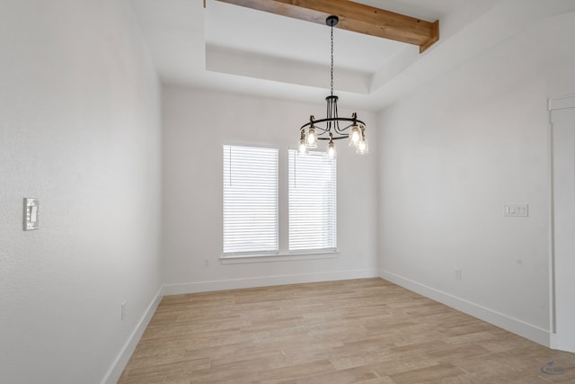 unfurnished dining area with a notable chandelier, baseboards, beam ceiling, light wood finished floors, and a raised ceiling