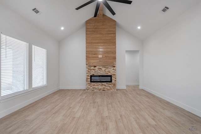 unfurnished living room with a stone fireplace, visible vents, a ceiling fan, light wood-type flooring, and beamed ceiling