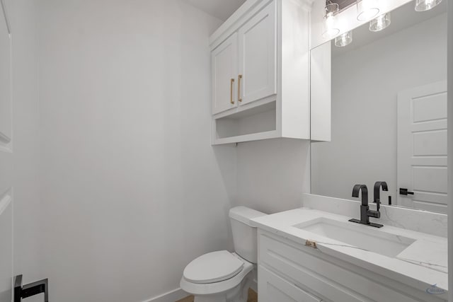 half bathroom with toilet, baseboards, and vanity