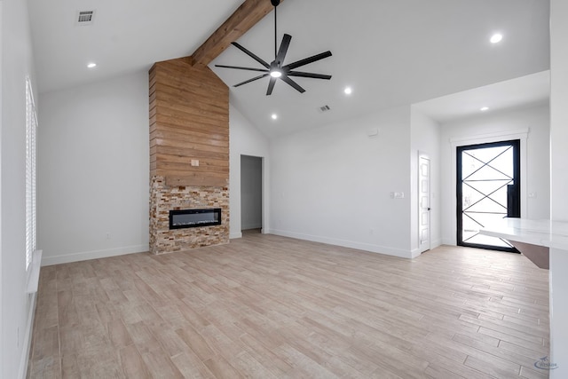 unfurnished living room with ceiling fan, a stone fireplace, light hardwood / wood-style floors, and beamed ceiling