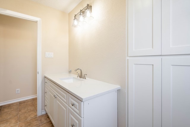 bathroom with vanity, baseboards, and tile patterned flooring