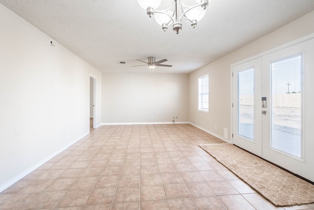 spare room with visible vents, ceiling fan with notable chandelier, a textured ceiling, french doors, and baseboards