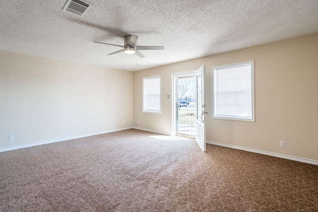 unfurnished room with visible vents, baseboards, carpet flooring, a textured ceiling, and a ceiling fan