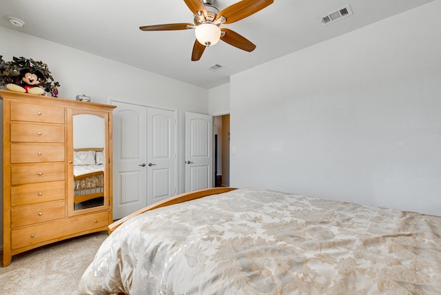 bedroom with a ceiling fan, visible vents, a closet, and light colored carpet