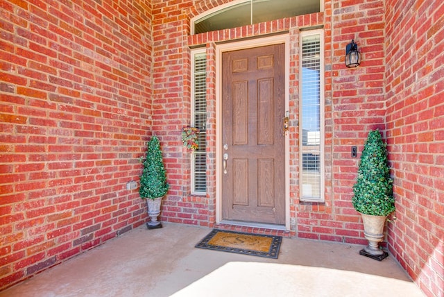 doorway to property with brick siding