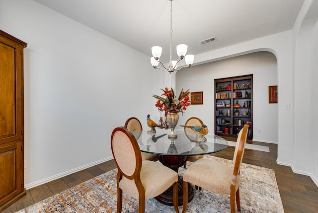 dining space with an inviting chandelier, visible vents, dark wood finished floors, and arched walkways