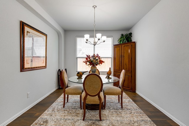 dining area with baseboards, dark wood-type flooring, and a notable chandelier