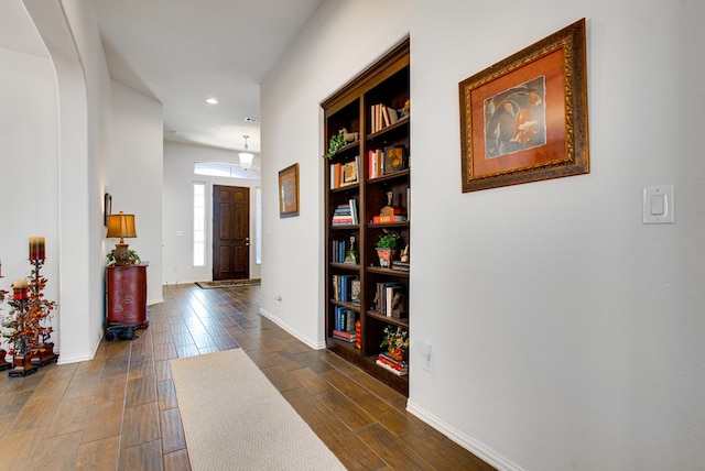 entryway with arched walkways, recessed lighting, dark wood finished floors, and baseboards