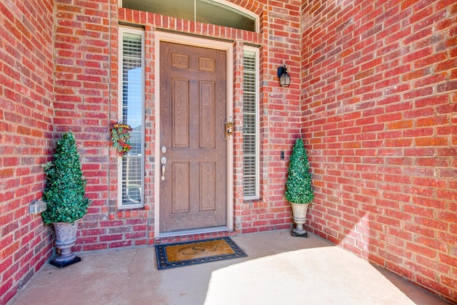 view of exterior entry with brick siding