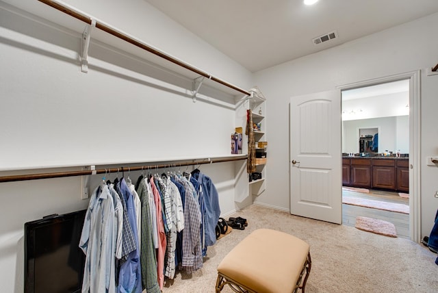 walk in closet featuring light carpet and visible vents