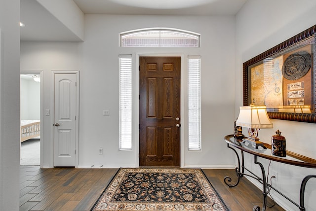 foyer featuring dark wood-type flooring and baseboards