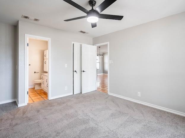 10807 E County Rd 104, Midland, TX 79706 - unfurnished bedroom featuring carpet floors, connected bathroom, and a ceiling fan