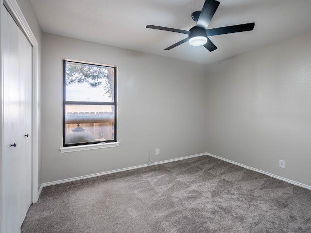 10807 E County Rd 104, Midland, TX 79706 - unfurnished bedroom featuring carpet flooring, a closet, and ceiling fan