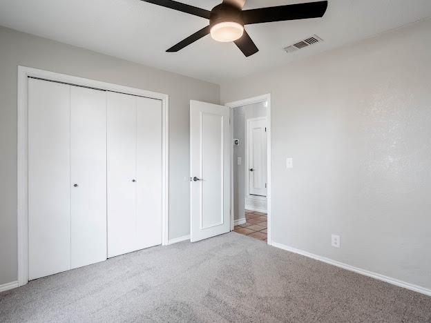 10807 E County Rd 104, Midland, TX 79706 - unfurnished bedroom featuring light carpet, a closet, and ceiling fan