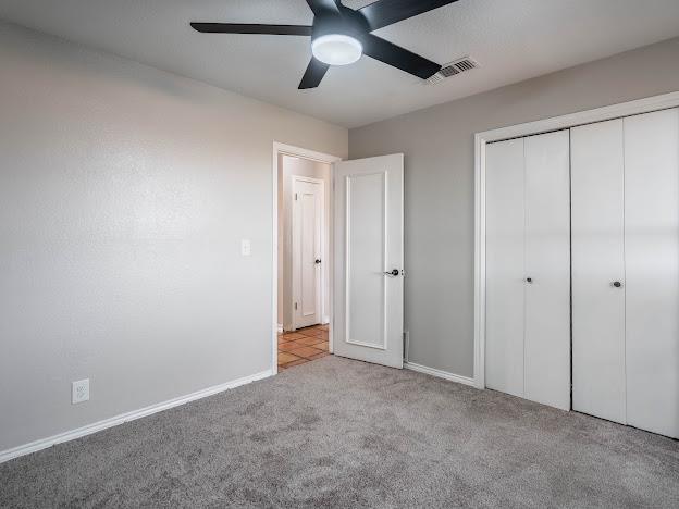 10807 E County Rd 104, Midland, TX 79706 - unfurnished bedroom featuring carpet flooring, a closet, and ceiling fan