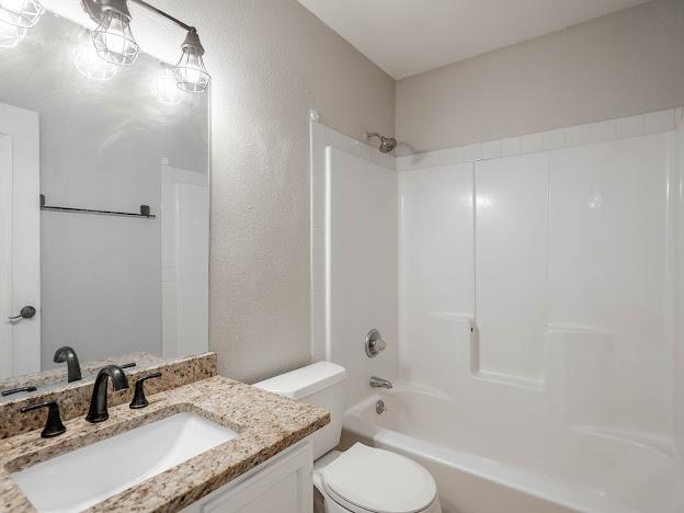 10807 E County Rd 104, Midland, TX 79706 - full bathroom featuring vanity, shower / washtub combination, and a textured wall