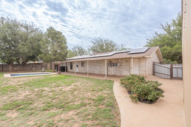 10807 E County Rd 104, Midland, TX 79706 - back of house with brick siding, a patio, solar panels, and a fenced backyard
