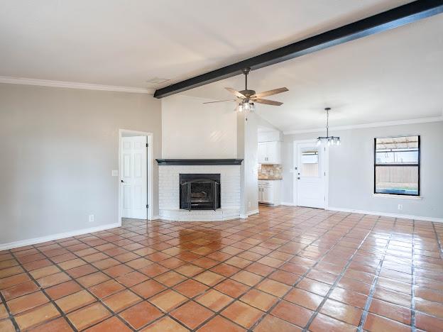 10807 E County Rd 104, Midland, TX 79706 - unfurnished living room with a ceiling fan, crown molding, light tile patterned flooring, and a brick fireplace