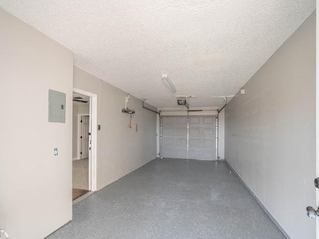 10807 E County Rd 104, Midland, TX 79706 - garage featuring electric panel and a garage door opener