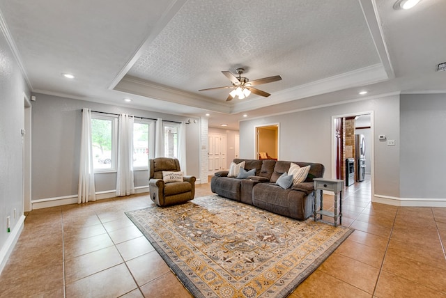 living room with baseboards, light tile patterned floors, and a raised ceiling