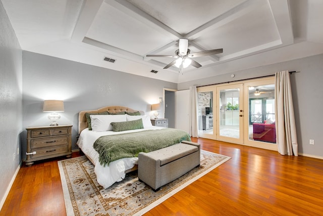 bedroom with wood finished floors, visible vents, coffered ceiling, and access to exterior